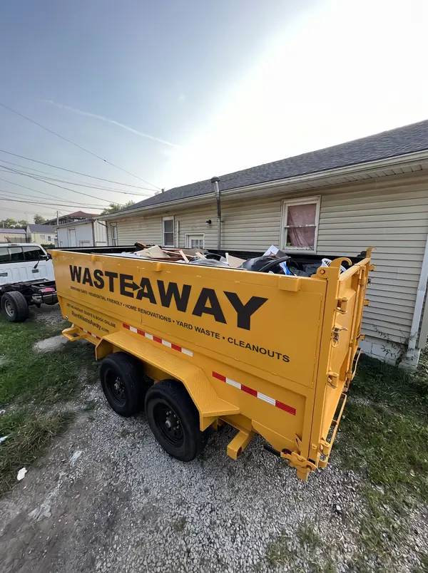 Waste Away dumpster placed on gravel beside a house