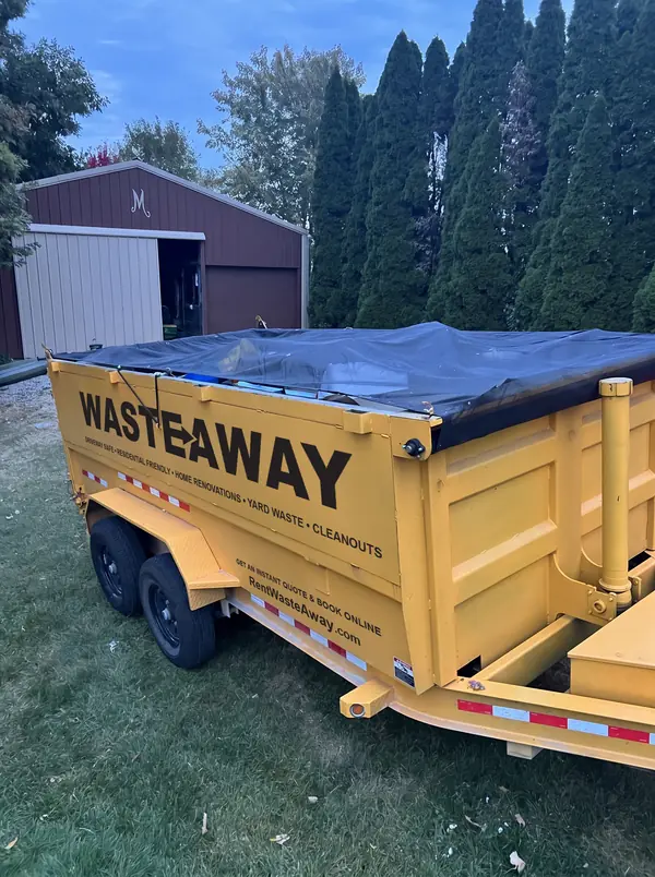 Waste Away dumpster tarped on a lawn after a full load